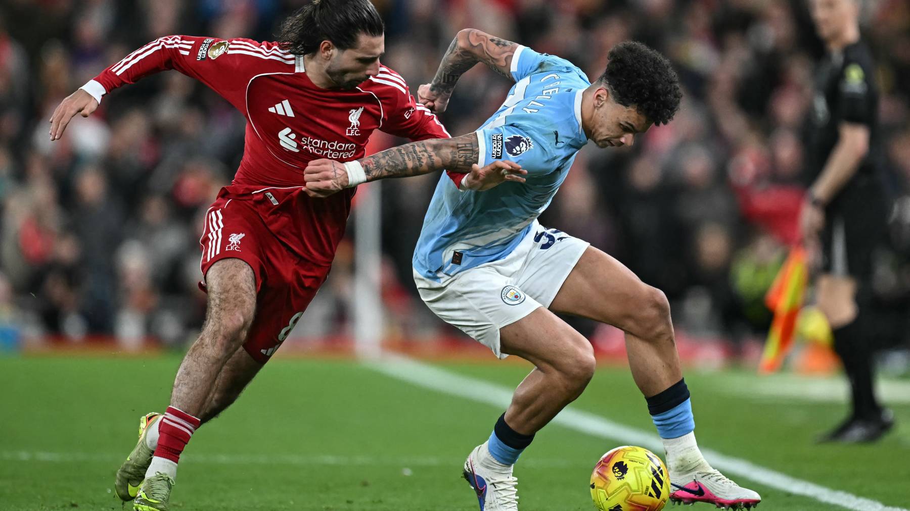 Manchester City's English midfielder #33 Nico O'Reilly (R) is challenged by Liverpool's Hungarian midfielder #08 Dominik Szoboszlai (L) during the English Premier League football match between Liverpool and Manchester City at Anfield in Liverpool, north west England on February 8, 2026.